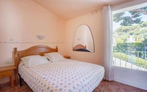 a bedroom with a bed and a large window at Casa Angels Tossa de Mar parking y wifi in Tossa de Mar