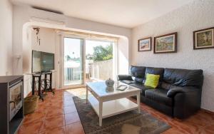 a living room with a black leather couch and a table at Casa Angels Tossa de Mar parking y wifi in Tossa de Mar