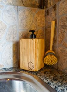 a wooden soap dispenser on a counter next to a sink at Mökki Apúlia in Apúlia