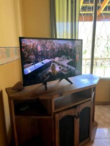 a flat screen tv sitting on top of a wooden table at La Diadema Casa de Montaña in Potrerillos