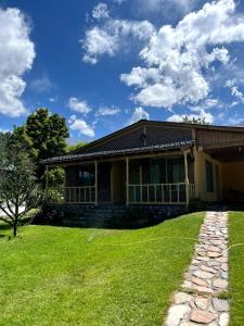 a house with a green lawn in front of it at La Diadema Casa de Montaña in Potrerillos