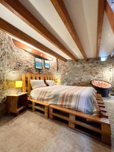 a bedroom with a wooden bed in a stone wall at Mökki Apúlia in Apúlia