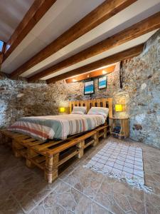 a bedroom with a bed in a stone wall at Mökki Apúlia in Apúlia