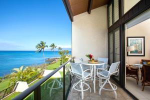 a balcony with a table and chairs and the ocean at K B M Resorts Napili Villa C31 Ocean Front 2BDRM in Kapalua