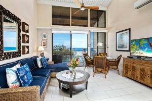a living room with a blue couch and a table at K B M Resorts Napili Villa C31 Ocean Front 2BDRM in Kapalua