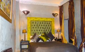 a bedroom with a bed with a yellow headboard at Riad Terra Bahia in Marrakesh