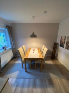 a dining room with a wooden table and chairs at Ferienwohnung „Maya“ in Langelsheim