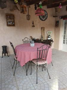 a table and chairs with a red and white table cloth at L'éolyre in La Motte-dʼAigues