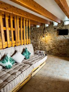 a couch in a room with a stone wall at Mökki Apúlia in Apúlia