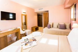 a living room with two beds and a television at Helianthus Guesthouse in Ammouliani