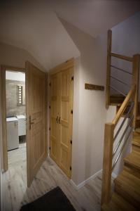 korytarz z drewnianymi drzwiami i schodami w domu w obiekcie Słoneczna Sielanka domki w Bieszczadach w mieście Ustrzyki Dolne