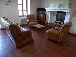 - un salon avec des fauteuils en cuir et une cheminée dans l'établissement ANCIEN RELAIS DE DILIGENCE, à Grambois
