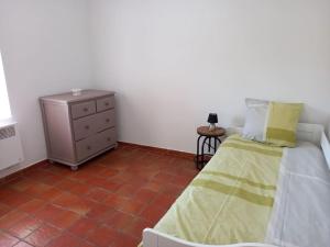 - une chambre avec un lit, une commode et du carrelage dans l'établissement ANCIEN RELAIS DE DILIGENCE, à Grambois