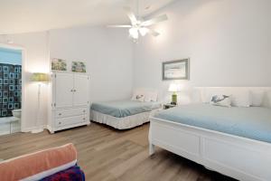 a bedroom with two beds and a ceiling fan at Chic Townhouse Steps to the Beach Outdoor Pools in Panama City Beach +35 photos