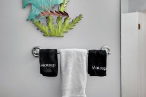 a bathroom with two towels hanging on a wall at Chic Townhouse Steps to the Beach Outdoor Pools in Panama City Beach