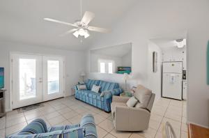 a living room with a blue couch and chairs at Chic Townhouse Steps to the Beach Outdoor Pools in Panama City Beach