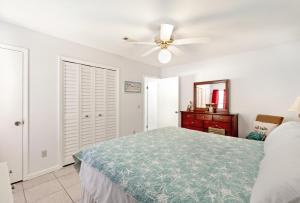 a bedroom with a bed and a ceiling fan at Chic Townhouse Steps to the Beach Outdoor Pools in Panama City Beach