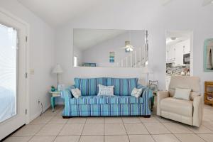 a living room with a blue couch and a chair at Chic Townhouse Steps to the Beach Outdoor Pools in Panama City Beach