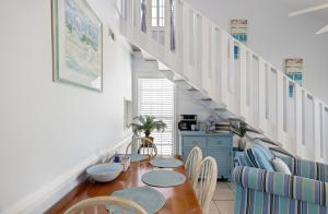 a dining room with a table and chairs and a staircase at Chic Townhouse Steps to the Beach Outdoor Pools in Panama City Beach