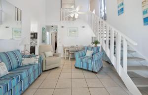 a living room with two couches and a staircase at Chic Townhouse Steps to the Beach Outdoor Pools in Panama City Beach