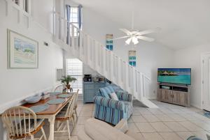 a living room with a dining table and a staircase at Chic Townhouse Steps to the Beach Outdoor Pools in Panama City Beach