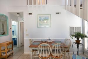 a dining room with a wooden table and chairs at Chic Townhouse Steps to the Beach Outdoor Pools in Panama City Beach