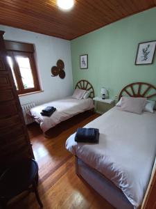 a bedroom with two beds and a window at Casa Lorente en Isuerre in Isuerre