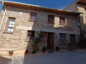 a stone building with windows and potted plants on it at Casa Lorente en Isuerre in Isuerre