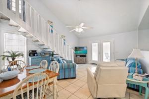 a living room with a staircase and a table and chairs at Chic Townhouse Steps to the Beach Outdoor Pools in Panama City Beach