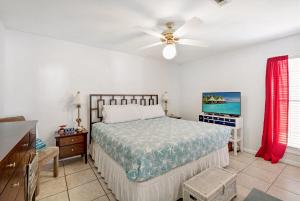 a bedroom with a bed and a ceiling fan at Chic Townhouse Steps to the Beach Outdoor Pools in Panama City Beach