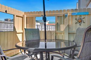 a patio with a glass table and chairs on a fence at Chic Townhouse Steps to the Beach Outdoor Pools in Panama City Beach