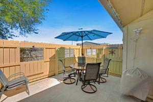 a patio with a table and chairs and an umbrella at Chic Townhouse Steps to the Beach Outdoor Pools in Panama City Beach