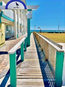 a boardwalk leading to the beach with a building at Chic Townhouse Steps to the Beach Outdoor Pools in Panama City Beach