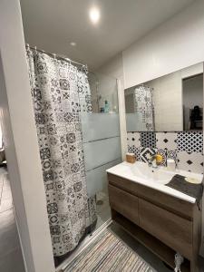 a bathroom with a sink and a shower curtain at perle rare à la ciotat in La Ciotat