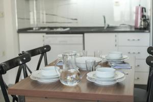 una mesa de madera con platos y vasos. en Atli Apart, en Fethiye