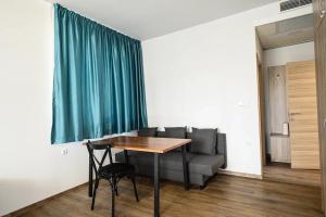 a living room with a table and a couch at Хотел Добруджа in Shumen