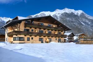 un gran edificio con nieve frente a una montaña en Ostbacher Stern, en Leutasch