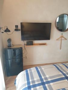 Schlafzimmer mit einem Flachbild-TV an der Wand in der Unterkunft Tiny studio 2 min walking distance from the port in Volos