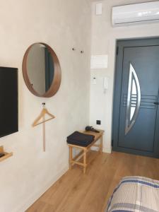 Cette chambre est dotée d'une porte bleue et d'un miroir. dans l'établissement Tiny studio 2 min walking distance from the port, à Vólos