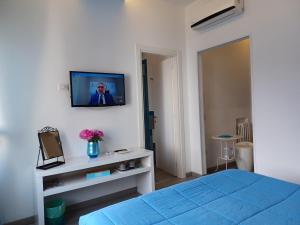 - une chambre avec un lit et une télévision murale dans l'établissement Giulia BB Sorrento, à Sorrente
