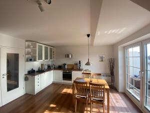 a kitchen with white cabinets and a table and chairs at Apartment Luise in Friedrichskoog