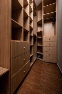 a walk in closet with wooden shelves and cabinets at Villa Lara in Sparta