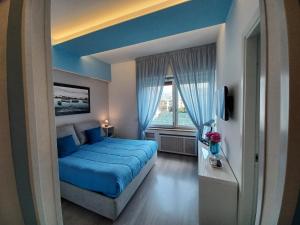 - une chambre avec un lit bleu et une fenêtre dans l'établissement Giulia BB Sorrento, à Sorrente