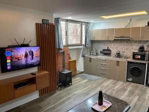 a living room with a tv and a kitchen at Harmony climatisé in Azrou