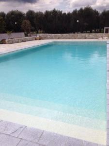 une grande piscine d'eau bleue dans l'établissement La Carcara, à Otrante