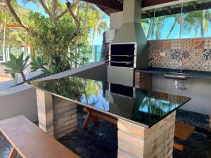 cocina al aire libre con barra y mesa en Porto Paúba Flat 116 en Pauba