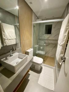 a bathroom with a sink and a toilet at Porto Paúba Flat 116 in Pauba