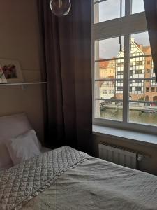 a bedroom with a bed and a window at River View in Gdańsk