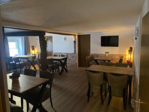 a restaurant with wooden tables and chairs and a television at Hotel Unter den Linden in Kierspe