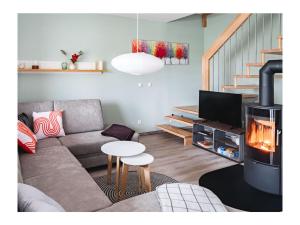 a living room with a couch and a fireplace at Ferienhaus Familienkoje Hannah in Krummin